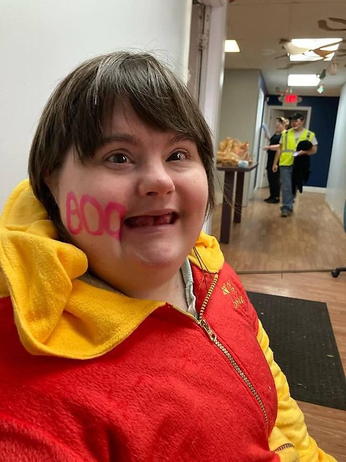 A member in a Winnie the Pooh costume with Boo face paint, all smiles