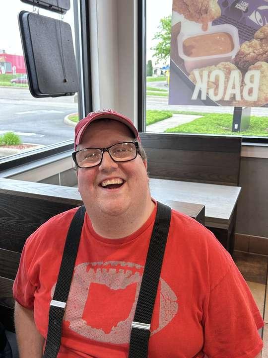A member smiling big during a lunch outing