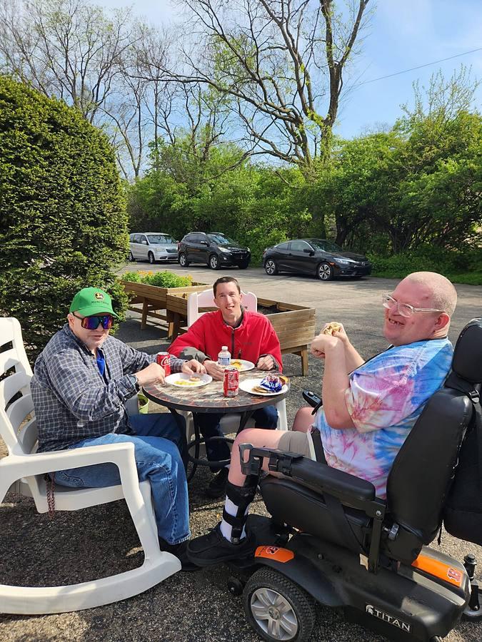 Three members sharing breakfast on the patio