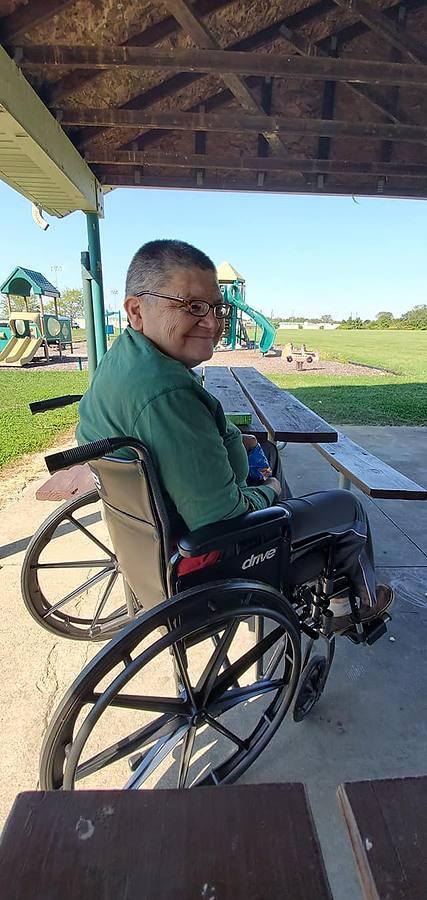 A member smiling at a picnic table at the park