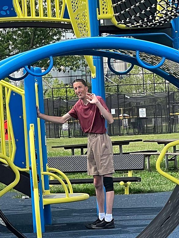 A member smiling and waving from the playground