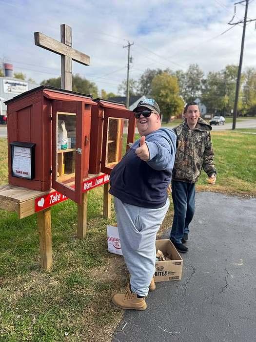 A member giving a big thumbs up at a community little pantry