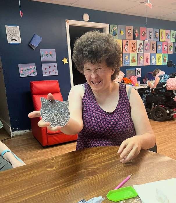 A member carefully painting a small tile