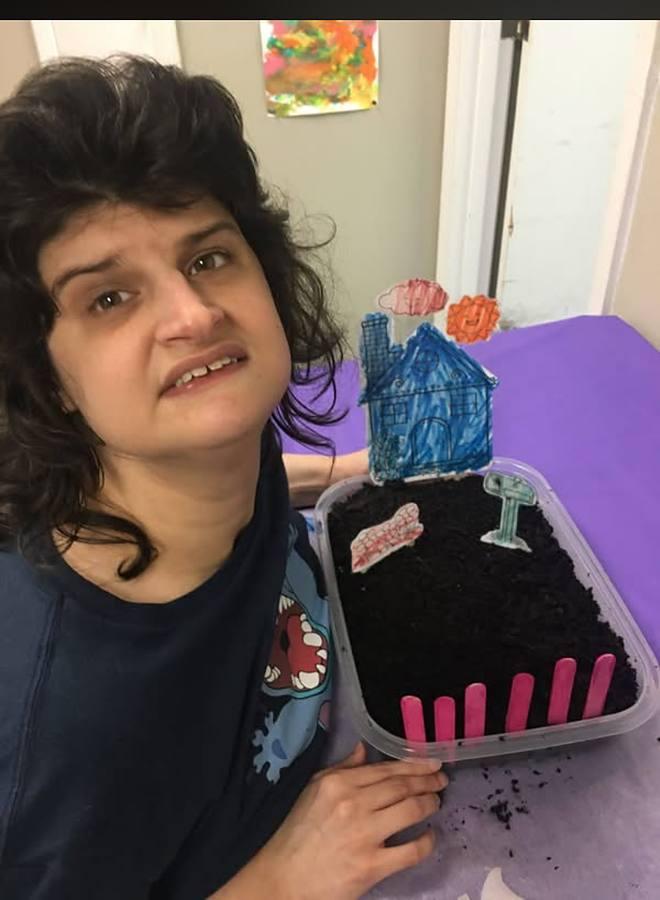 A member showing off the mini garden she made